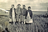 Ardnt Ketterling's mom (l-r) Othelia, in the field with Emma Wolff and Othelia's sisters, Eva and Adeline. They hold pitchforks for tossing shock bundles for hay. Circa 1930s.	
