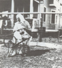 A German from Russia "hausfrau" photographed in Saskatchewan in 1934 with her spinning wheel from her homeland.