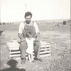 Inez with father Juluis, sitting on a chicken crate, 1937.