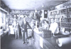 Fred Flemmer, right, served customers in a grocery/dry goods store in Beulah's early days. Note the gloves and socks hanging from the ceiling and the canned goods on the shelves.