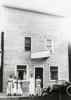 The Elgin Cafe owned and operated by Anna Rendahl in approximately 1918. Pictured from left to right are Margaret and Leona Rendahl, daughters of Anna Rendahl. Leo Rendahl, Anna's son, is peeking out of the window.